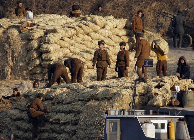 북한 군인들이 신의주 인근 압록강 제방에서 화물선으로부터 쌀 포대를 내리고 있다. 사진=RFA 홈페이지 캡처