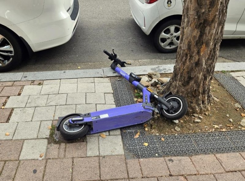 인도 위에 쓰러져 있는 전동 킥보드. 연합뉴스 제공