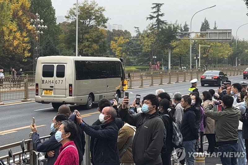 2일 중국 베이징의 '바바오산 혁명공원'으로 향하는 고 리커창 총리의 운구 차량 행렬을 연도의 시민들이 휴대전화로 찍고 있다. 중국 정부는 혁명공원에서 리 전 총리의 영결식을 치른 뒤 시신을 화장한 것으로 알려졌다. 사진=AP 연합뉴스