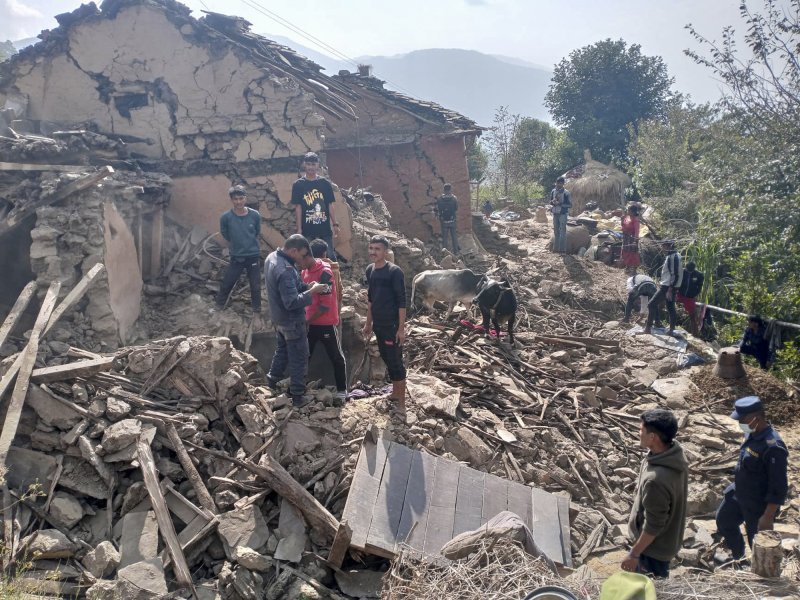지난해 11월 9일(현지시간) 네팔 서부 산악지대 도티 지역에서 지진이 발생해 주민들이 무너진 진흙집 잔해 속에 서 있다. 뉴시스 제공