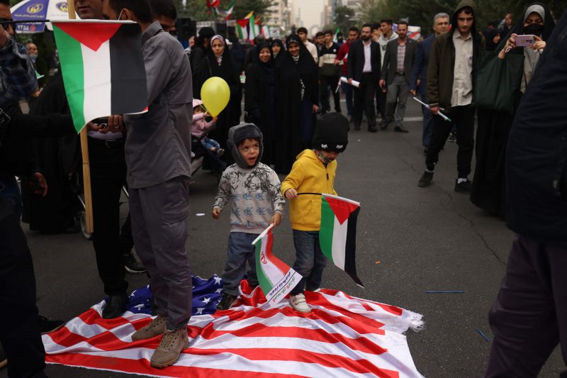 이란 수도 테헤란에서 4일(현지시간) 팔레스타인 국기를 든 아이(오른쪽 첫번째)와 이란 국기를 든 아이가 미국 성조기를 밟고 있다.AFP연합뉴스