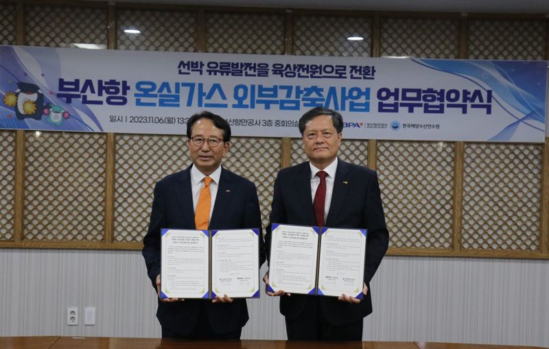 부산항만공사 강준석 사장(왼쪽)과 한국해양수산연수원 김민종 원장이 업무협약서를 들고 기념사진을 촬영하고 있다. 부산항만공사 제공