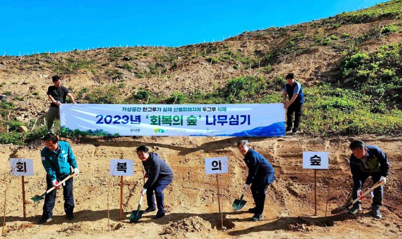 지난 3일 경북 울진에서 열린 ‘회복의 숲’ 식수 행사에서 두나무와 한국산림복지진흥원 등 관계자들이 나무를 심고 있다. 두나무 제