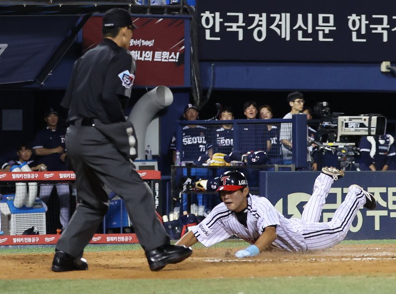31일 서울 송파구 잠실야구장에서 열린 '2023 신한은행 SOL KBO리그' LG 트윈스와 두산 베어스의 경기 8회말 1사 만루 상황에서 LG 박동원의 스퀴즈 번트 때 3루 주자 최승민이 슬라이딩하고 있다. 2023.8.31/뉴스1 ⓒ News1 김민지 기자