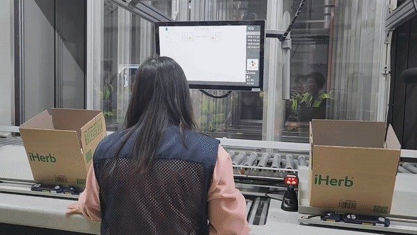 오토스토어가 내려보낸 상품을 1층에 있는 작업자가 상자에 옮겨 담고 있다./뉴스1 ⓒ News1 이정후 기자