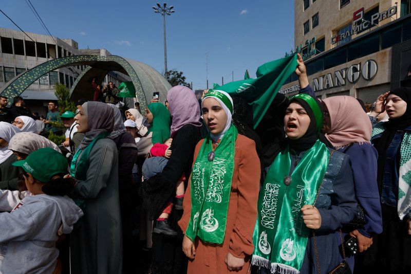 지난달 18일(현지시간) 팔레스타인 요르단강 서안지구의 헤브론에서 무장정파 하마스를 지지하는 팔레스타인 주민들이 하마스를 상징하는 문양과 깃발을 든 채 행진하고 있다. 로이터 뉴스1