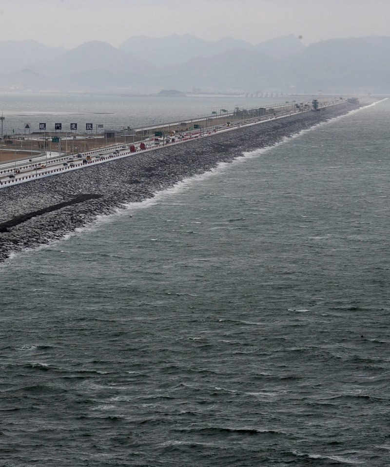 【군산=뉴시스】박종민 기자 = 28일 오후 전체 길이 33.9Km에 달하는 세계 최장 방조제인 새만금방조제가 웅장한 모습을 드러내고 있다. 지난 1991년 11월 착공된 새만금방조제는 모두 2조9,000억원이 투입된 국내 최대의 토목공사로, 연간 237만명의 인력과 91만대의 건설장비가 동원됐고 방조제 건설에는 모두 1억2,300만㎥의 토사가 투입됐다. 이는 경부고속도로 4차선을 13ｍ높이로 쌓을 수 있는 어마어마한 양이다. 이렇게 완공된 새만금방조제는 그동안 세계에서 가장 긴 방조제였던 네덜란드 쥬다찌 방조제의 32.5㎞ 기록도 