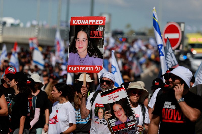 15일(현지시간) 이스라엘 텔아비브 외곽에서 지난달 7일 하마스에게 가족과 지인을 납치당한 시위대가 인질들의 사진을 들고 인질 석방을 요구하며 행진하고 있다.로이터연합뉴스