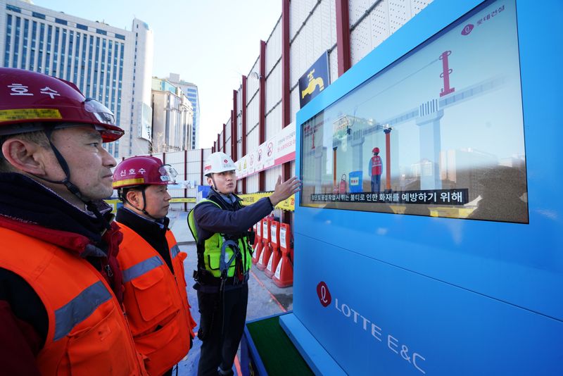 지난 15일 수도권의 한 아파트 현장에서 근로자들이 공종별 61종의 필수 안전수칙 애니메이션 영상을 시청하고 있다. 롯데건설 제공