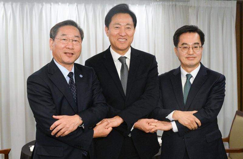유정복 인천시장(왼쪽부터), 오세훈 서울시장, 김동연 경기도지사가 16일 오후 서울 중구 프레스센터에서 가진 3자 회동에 앞서 손을 맞잡고 있다. 뉴스1