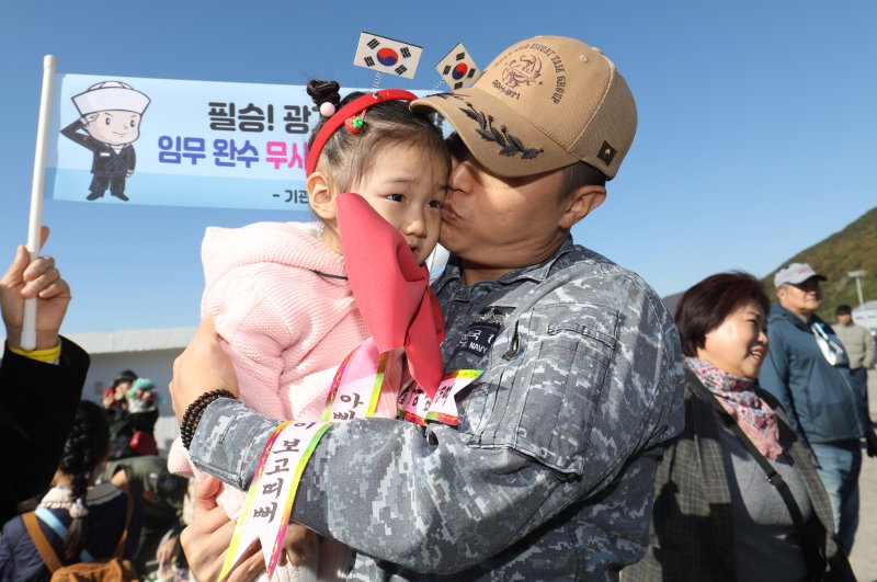 17일 경남 창원시 진해구 진해군항에서 열린 '청해부대 40진(광개토대왕함) 파병 복귀 환영 행사'에서 임무를 마치고 복귀한 청해부대원이 딸과 인사를 나누고 있다.<div id='ad_body3' class='mbad_bottom' ></div> 사진=뉴스1