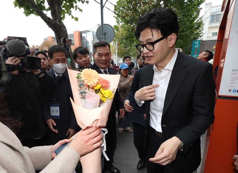 한동훈 법무부 장관이 지난 17일 대구 수성구 스마일센터 방문 중 한 시민에게 꽃다발을 받고 있다. 연합뉴스
