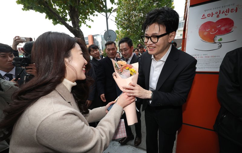 한동훈 법무부 장관이 17일 대구시 수성구 스마일센터 방문 중 한 시민에게 꽃다발을 받고 있다. 연합뉴스