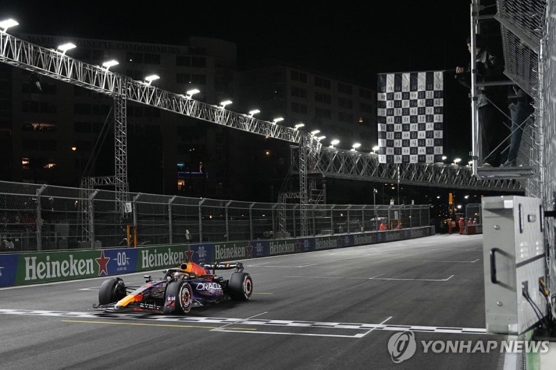 가장 먼저 체커기를 받는 막스 페르스타펀의 머신 Red Bull driver Max Verstappen, of the Netherlands, wins the Formula One Las Vegas Grand Prix auto race, Saturday, Nov. 18, 2023, in Las Vegas. Justin Bieber waves the checkered flag. (AP Photo/Darron Cummings)