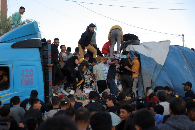21일(현지시간) 가자기구 칸유니스에서 팔레스타인인들이 식량과 물을 실은 화물차에 몰려 구호 물자를 받고있다.신화연합뉴스