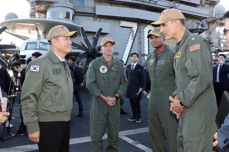 신원식 국방부장관(좌측 첫번째)이 2023년 11월 22일 해군 부산작전기지에 입항한 미국 제1항모강습단의 칼빈슨함을 방문해 제1항모강습단장 카를로스 사르디엘로 준장과 대화를 나누고 있다. 사진=국방부 제공