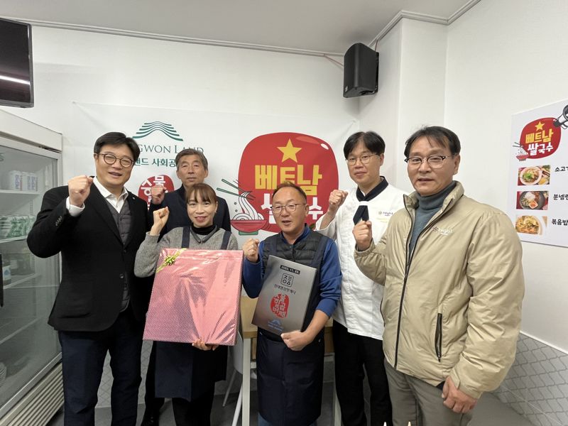 정태영삼 맛캐다 27호점주 황티후에씨를 비롯한 강원랜드사회공헌재단 관계자들이 23일 재개장식에서 기념촬영을 하고 있다. 강원랜드 제공