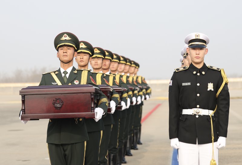 지난해 11월 23일 인천국제공항에서 제10차 중국군 유해 인도식이 열려 한국 군인들이 중국 의장대에게 중국군의 유해가 담긴 함을 인도한 후 함께 도열해 있다. 국방부는 6·25전쟁 중 한국 땅에서 전사한 중국군 유해 25구와 유품 335점을 중국 측에 인도했다. 한국은 2014년부터 중국군 유해를 인도해 지금까지 938구의 유해를 인도한 것으로 집계됐다. 사진=신화·뉴시스