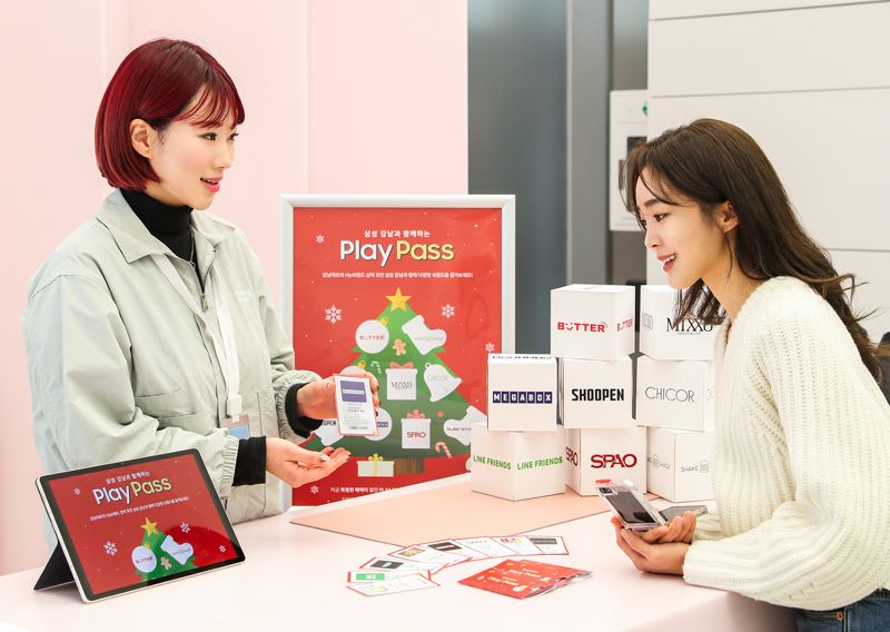 삼성전자 모델이 '삼성 강남' 방문 고객들에게 제공하는 쿠폰북 '플레이 패스'를 살펴보고 있다. 삼성전자 제공