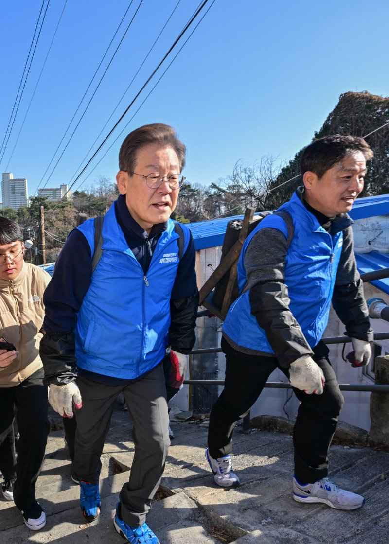 더불어민주당 이재명 대표(왼쪽)가 4일 오전 서울 성북구 보국문로 주택가에서 연탄 나눔 봉사활동을 하고 있다. 연합뉴스