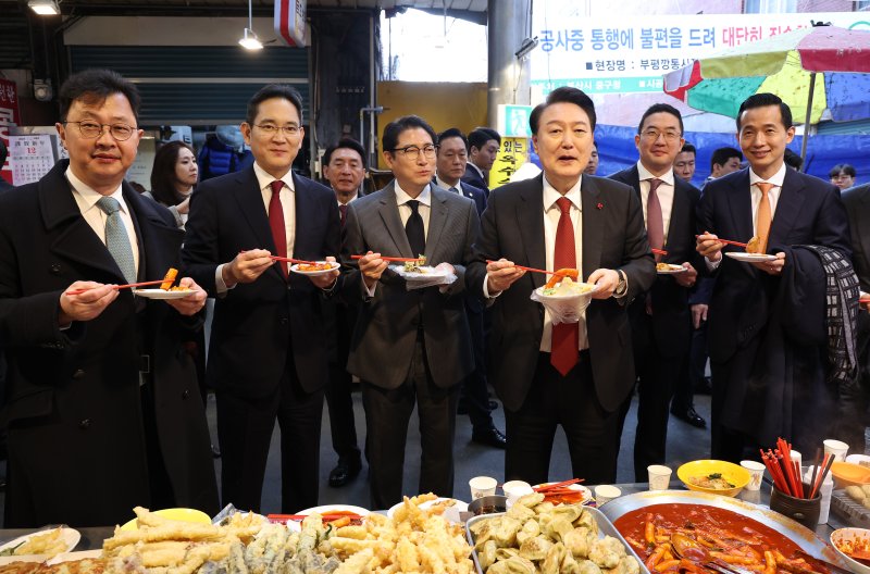 윤석열 대통령이 6일 부산 중구 깡통시장을 방문해 기업인들과 떡볶이를 맛보고 있다. 왼쪽부터 최재원 SK 수석부회장, 이재용 삼성전자 회장, 조현준 효성 그룹 회장, 윤 대통령, 구광모 LG그룹 회장, 김동관 한화그룹 부회장. (대통령실통신사진기자단) /사진=뉴시스