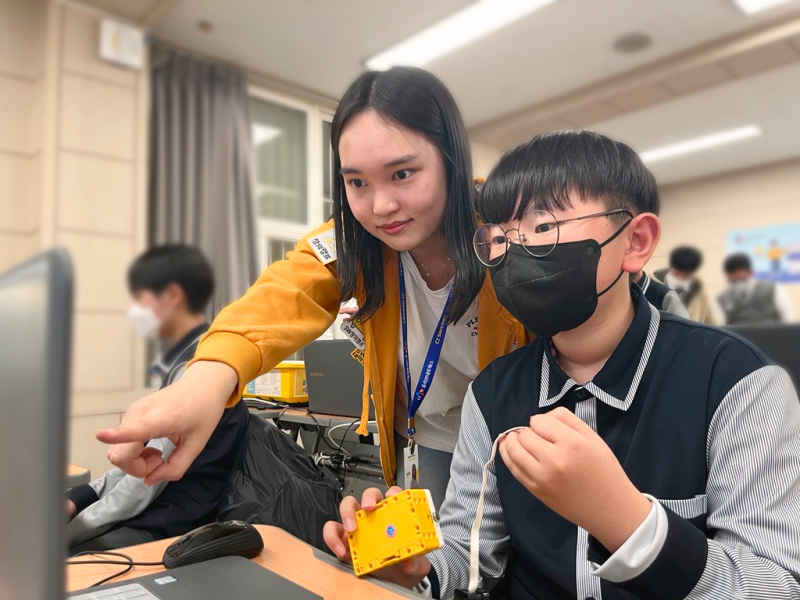 CJ올리브네트웍스의 'CJ SW창의캠프'에 참가한 충북 제천중학교 학생이 CJ올리브네트웍스 직원과 함께 AI와 레고(LEGO) 파이썬 코딩을 활용해 로봇을 만들고 있다. CJ올리브네트웍스 제공