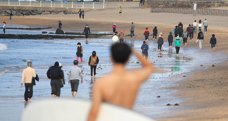 [제주=뉴시스] 우장호 기자 = 주말 휴일동안 낮 기온이 20도를 훌쩍 웃도는 등 포근한 날씨를 보인 10일 오후 제주시 이호해수욕장을 찾은 시민들이 맨발로 해변을 걸어가고 있다. 기상청에 따르면 이날 오후부터 11일까지 제주도에 최대 100㎜ 이상 폭우가 쏟아지며 기상이 악화할 것으로 예보됐다. 2023.12.10. woo1223@newsis.com