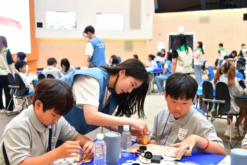 지난 8월 열린 '푸른꿈 환경학교'에서 포스코퓨처엠 직원이 어린이와 함께 전기차 모형을 제작하고 있다. 포스코퓨처엠 제공