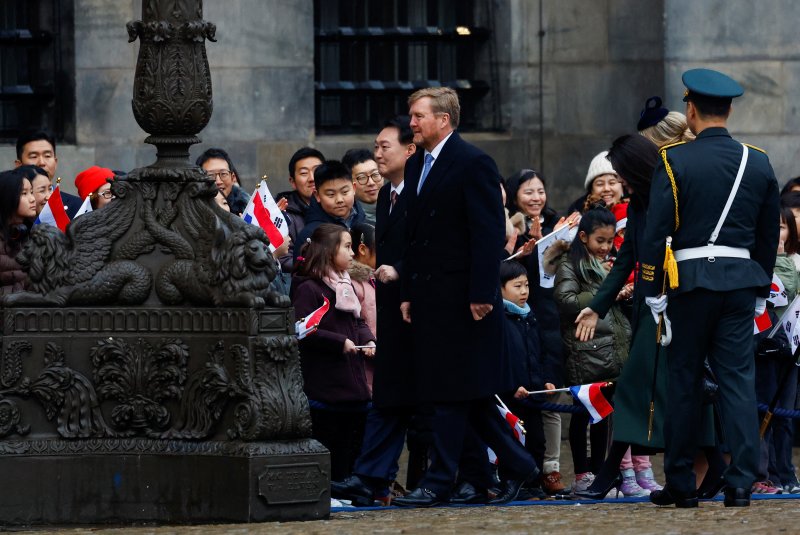 윤석열 대통령이 12일 오전(현지시간) 네덜란드 암스테르담 담(Dam) 광장에서 열린 국빈 방문 공식환영식에서 태극기와 네덜란드 국기를 흔들고 있는 교민들과 만나 인사를 나눈 뒤 왕궁으로 이동하고 있다. 2023.12.12/뉴스1 ⓒ 로이터=뉴스1 ⓒ News1 정지형 기자