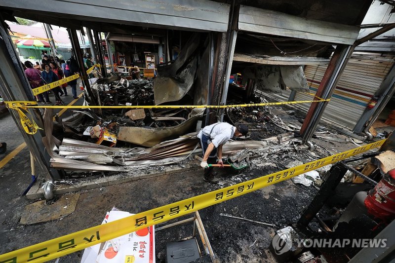 지난 9월 광주 광산구 비아5일시장에서 화재가 발생해 상인이 잔해를 정리하고 있다. 연합뉴스
