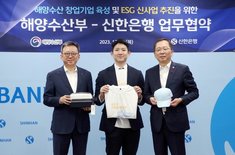 14일 서울 중구 신한은행 본점에서 진행된 '해양수산 창업기업 육성 및 ESG 신사업 추진' 업무협약식에서 정상혁 신한은행장(왼쪽), 조승환 해양수산부 장관(오른쪽), 이민재 쿨베어스 대표가 친환경 소재로 만든 의류 및 물품을 들고 기념촬영하고 있다.(사진=신한은행 제공)