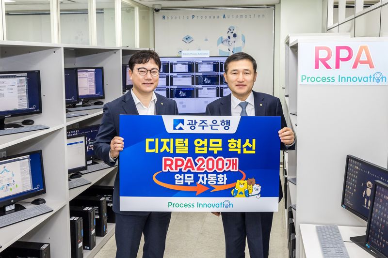 광주은행이 업무 효율화 개선과 핵심 업무 집중을 위해 지난 2019년 RPA(Robotic Process Automation, 로봇프로세스자동화) 시스템을 도입한 후 최근 200개 업무 자동화를 구현한 가운데 고병일 은행장(사진 오른쪽)이 업무 책임자인 나선진 프로세스혁신부장(왼쪽)과 기념촬영을 하고 있다. 광주은행 제공