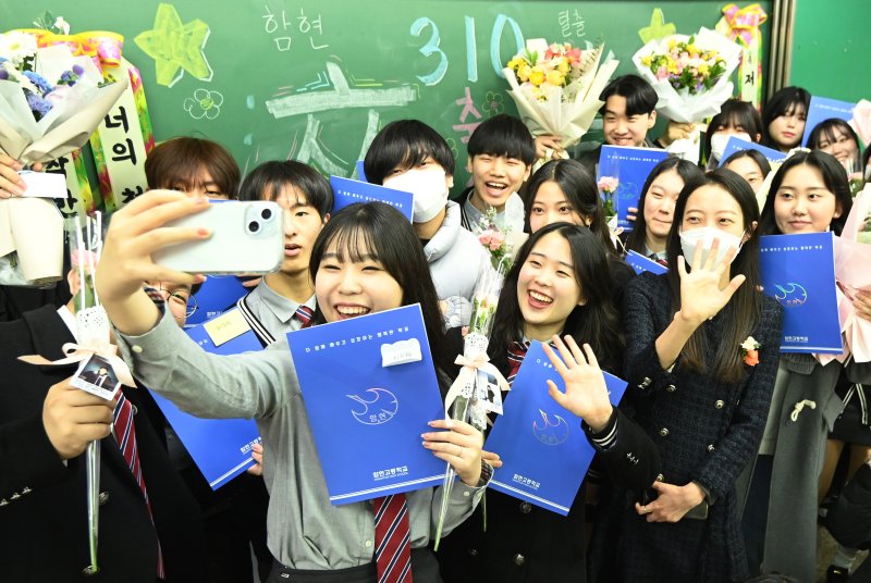 [시흥=뉴시스] 김종택 기자 = 12일 경기도 시흥시 함현고등학교에서 열린 졸업식에서 학생들이 선생님과 함께 기념촬영 하며 추억을 남기고 있다. 2023.12.12. jtk@newsis.com