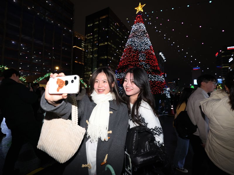 15일 오후 서울 세종대로 광화문광장에서 열린 ‘2023 서울빛초롱축제’에서 시민들이 대형 미디어트리를 배경으로 셀카를 찍고 있다. 이번 행사는 이날 개막해 내년 1월 21일까지 38일간 진행된다. 2023.12.15/뉴스1 ⓒ News1 김진환 기자