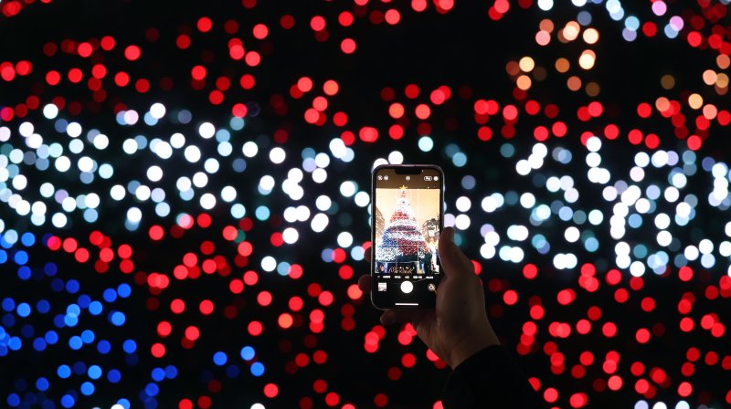 15일 오후 서울 세종대로 광화문광장에서 열린 ‘2023 서울빛초롱축제’에서 한 시민이 미디어트리를 스마트폰으로 촬영하고 있다. 이번 행사는 이날 개막해 내년 1월 21일까지 38일간 진행된다. 2023.12.15/뉴스1 ⓒ News1 김진환 기자