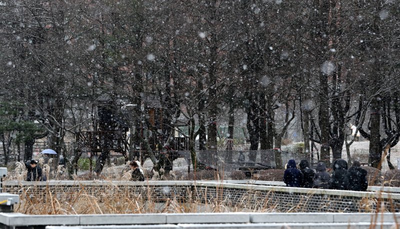 전북지역에 대설주의보가 내려진 16일 전북 전주시 덕진공원에서 산책을 하던 시민들이 쏟아지는 눈을 피해 발걸음을 재촉하고 있다. 2023.12.16/뉴스1 ⓒ News1 유경석 기자