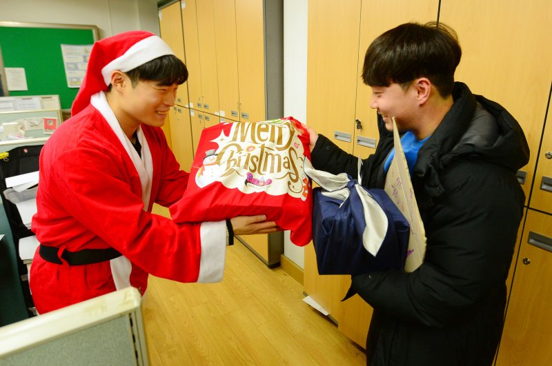 크리스마스를 앞두고 일일 산타가 광주 광산구 천곡중학교에서 한 선생님에게 선물꾸러미를 전달하고 있다. 2023.12.19/뉴스1 ⓒ News1 이승현 기자