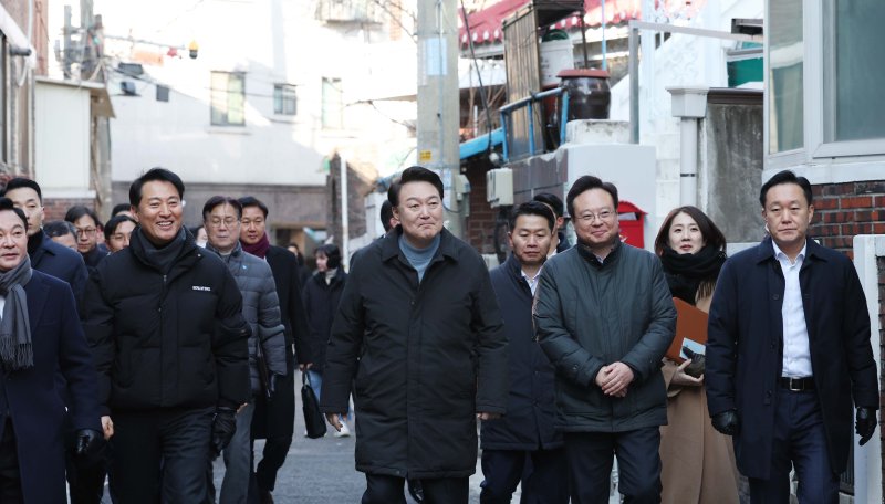 윤석열 대통령이 21일 서울 중랑구의 소규모주택정비 관리지역인 모아타운 사업지를 방문해 원희룡 국토교통부 장관, 오세훈 서울시장, 조규홍 보건복지부 장관 등과 함께 현장을 시찰하고 있다. [대통령실통신사진기자단] 연합뉴스