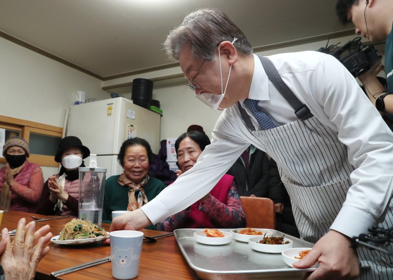 (서울=뉴스1) 국회사진취재단 = 이재명 더불어민주당 대표가 21일 오전 서울 영등포구 구립 큰숲 경로당에서 어르신들의 점심 식사 자리에 반찬을 놓고 있다. 2023.12.21/뉴스1 /사진=뉴스1화상