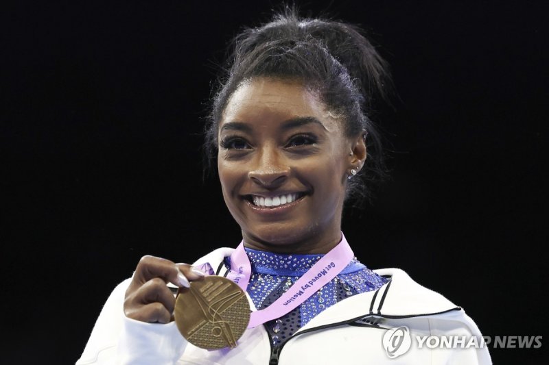 2년 만에 복귀해 세계선수권대회 개인종합 우승한 바일스 FILE - United States' Simone Biles shows her gold medal after the women's all-round final at the Artistic Gymnastics World Championships in Antwerp, Belgium, Friday, Oct. 6, 2023. Biles was named the AP Female Athlete of the Year for a third time on Friday, Dec. 22, 20