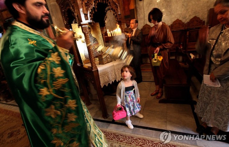 2012년 4월 성포르피리우스 교회에서 미사를 거행 중인 모습 epa03176073 A Palestinian Christian Orthodox family attends a Palm Sunday mass at the Saint Porphyrius church in Gaza City, 08 April 2012. Eastern Orthodox churches celebrate Easter according to the Julian calendar. EPA/MOHAMMED SABER
