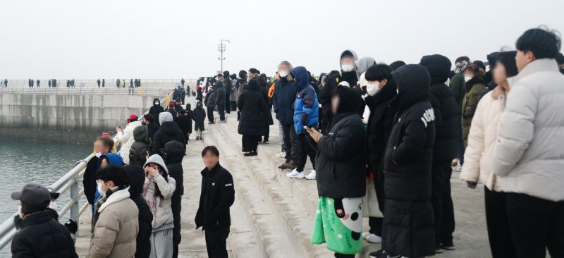 [군산=뉴시스] 김얼 기자 = 2023년 계묘년(癸卯年)의 첫날인 1일 전북 군산시 비응항을 찾은 시민들이 일출을 기다리고 있다. 2023.01.01. pmkeul@newsis.com