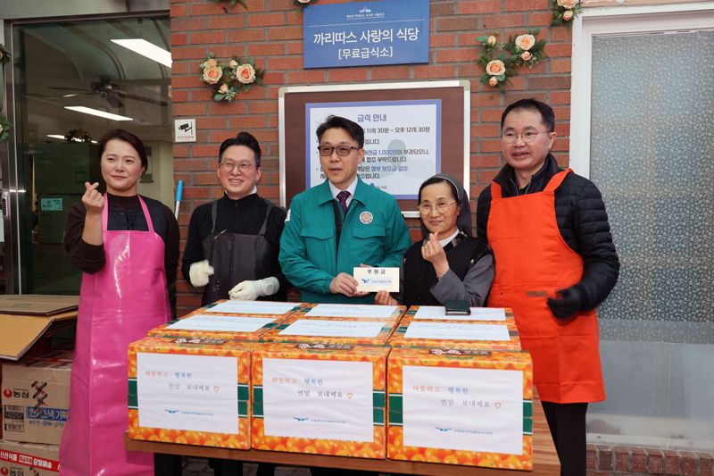 김진욱 고위공직자범죄수사처장이 26일 서울 서초구 까리따스 사랑의 식당에서 지역 소외 이웃을 위한 무료급식 봉사활동에 앞서 직원들이 모금한 성금을 전달하고 있다. 사진=서동일 기자