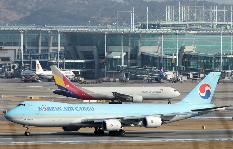 지난해 12월 26일 인천국제공항 계류장에 대한항공과 아시아나항공의 항공기가 지나고 있다. 뉴스 1 제공