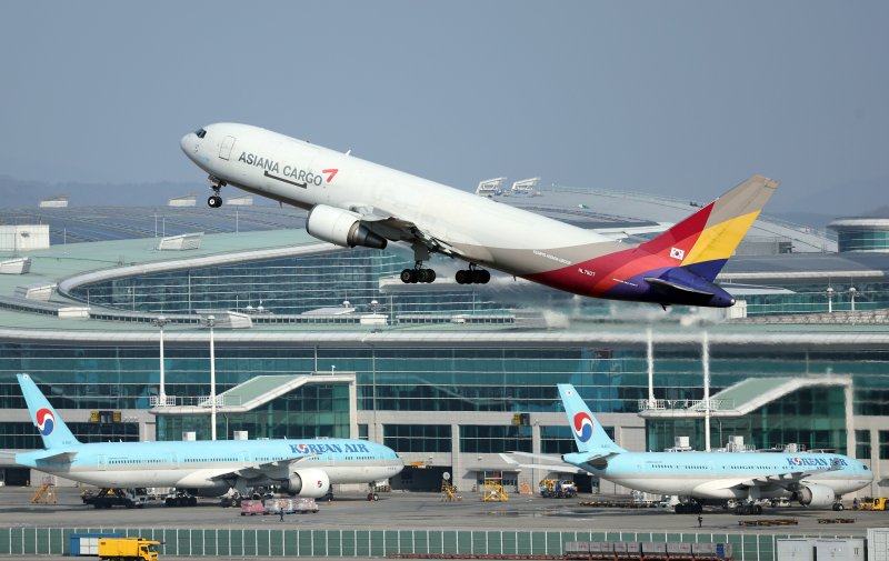대한항공과 아시아나항공의 합병이 해를 넘기게 된 가운데 26일 오후 인천국제공항 계류장에 대한항공과 아시아나항공의 항공기가 지나고 있다. 2023.12.26/뉴스1 ⓒ News1 박정호 기자