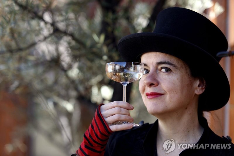 소설가 아멜리 노통브(2014년) epa04057793 Belgian writer Amelie Nothomb cheers with a glass as she poses for photographs during the presentation of her new book 'Barbe Bleu' (lit: Bluebeard) in Barcelona, Spain, 06 February 2014. Nothomb presents Charles Perrault's classic turned into a new version that inspir