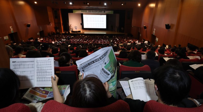 [서울=뉴시스] 김선웅 기자 = 지난 10일 서울 종로구 성균관대학교 600주년 기념관에서 열린 종로학원 개최 2024 정시지원 변화 및 합격선 예측, 합격전략 설명 대입설명회에서 참석 학부모 및 수험생들이 배치참고표를 살펴보는 모습. 2023.12.27. mangusta@newsis.com
