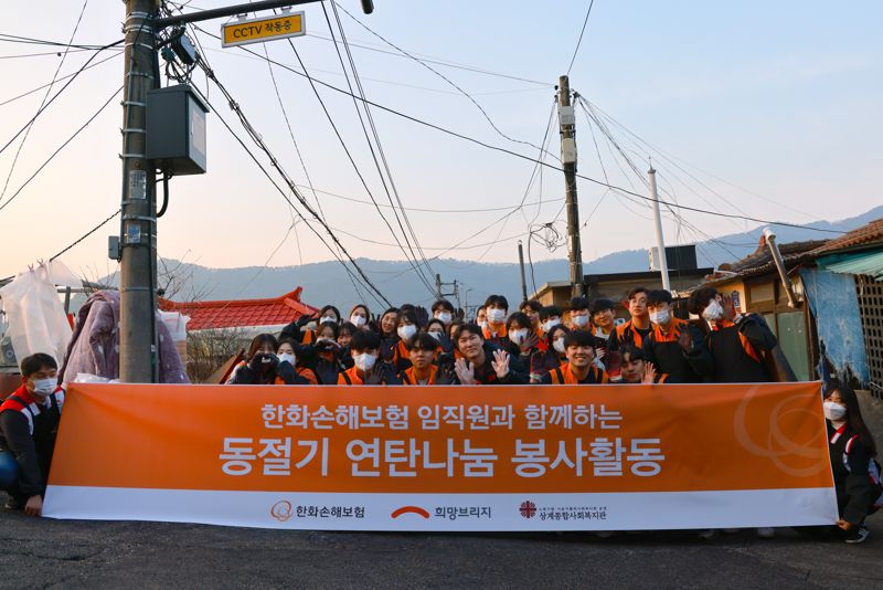 연말을 맞아 희망브리지와 한화손해보험이 전개한 연탄봉사활동에 참석한 참가자들이 기념 촬영을 하고 있다. 희망브리지 제공