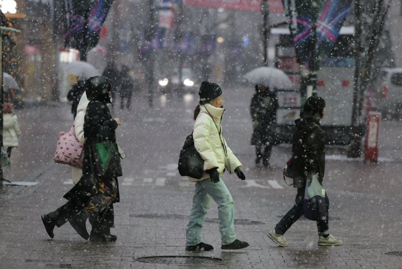 눈이 내리는 30일 오전 서울 중구 명동거리에서 관광객들이 길을 거닐고 있다. 사진=뉴스1