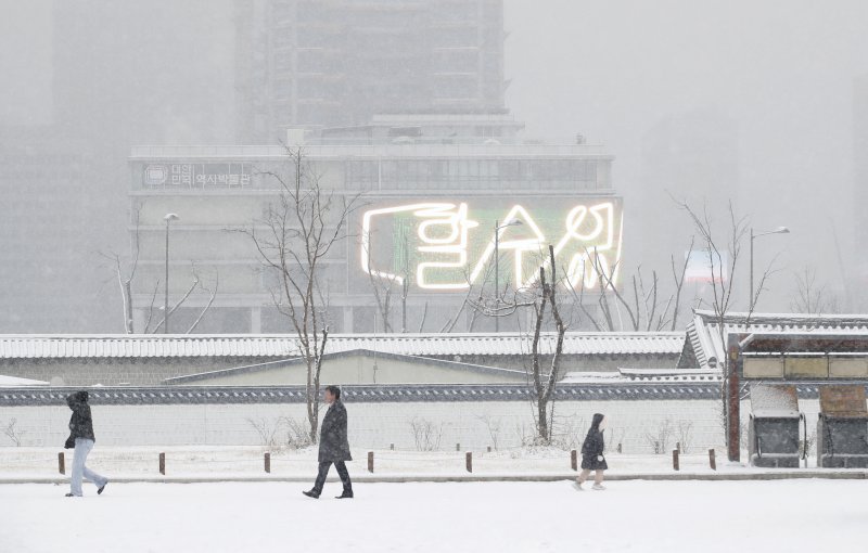 전국 대부분 지역에 눈이 내린 30일 오전 서울 종로구 경복궁을 찾은 관광객이 겨울 정취를 만끽하고 있다. 뉴스1